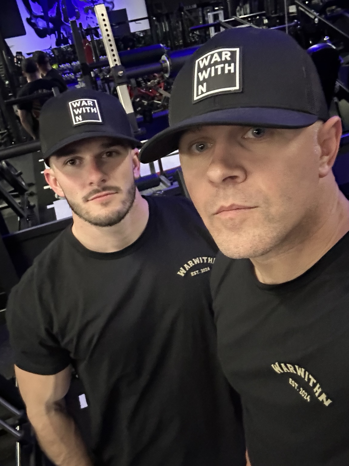 Jake and Adam together at the gym wearing WarWithN caps